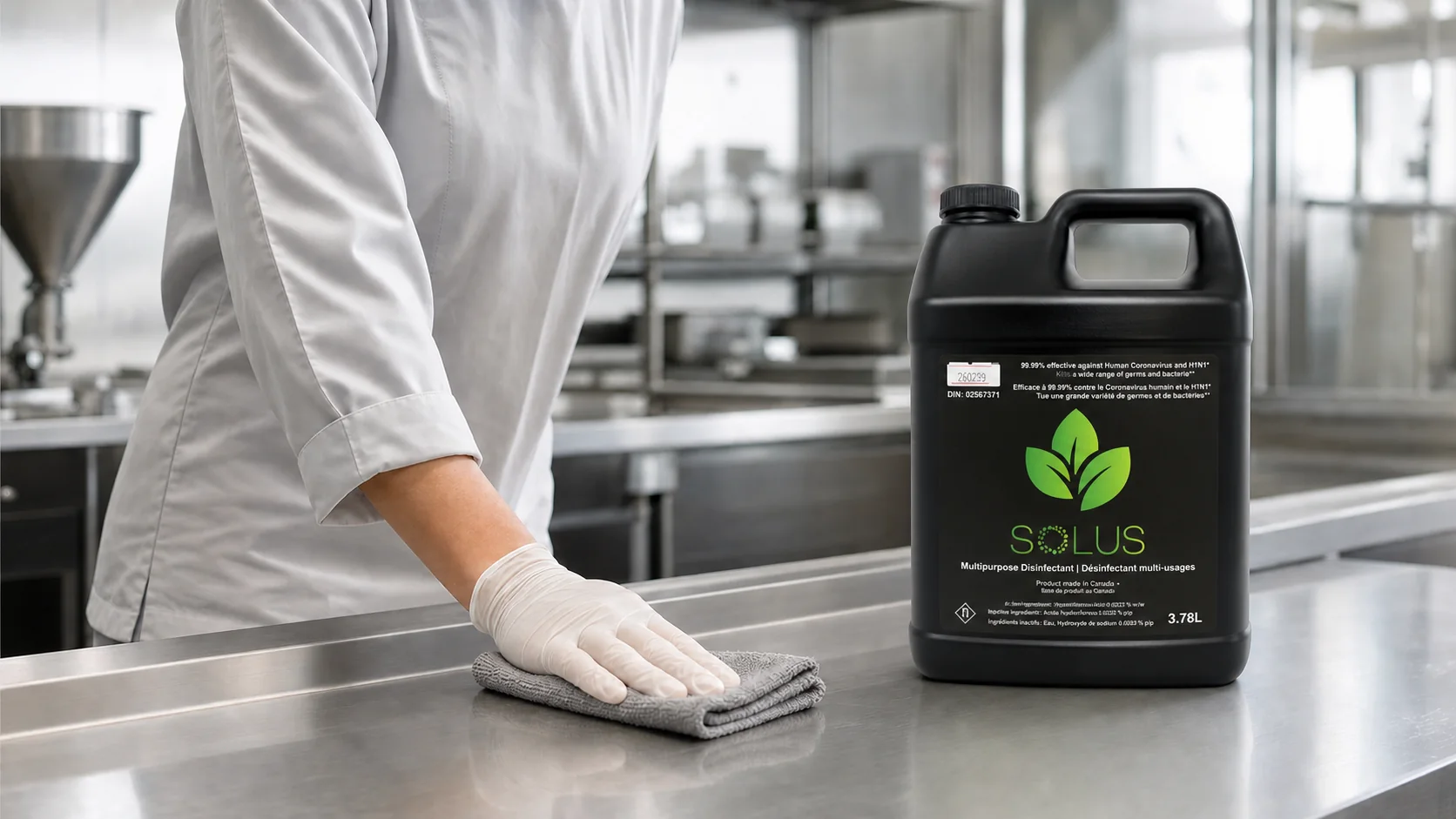 Worker wiping a stainless surface beside a black Solus HOCl disinfectant container.